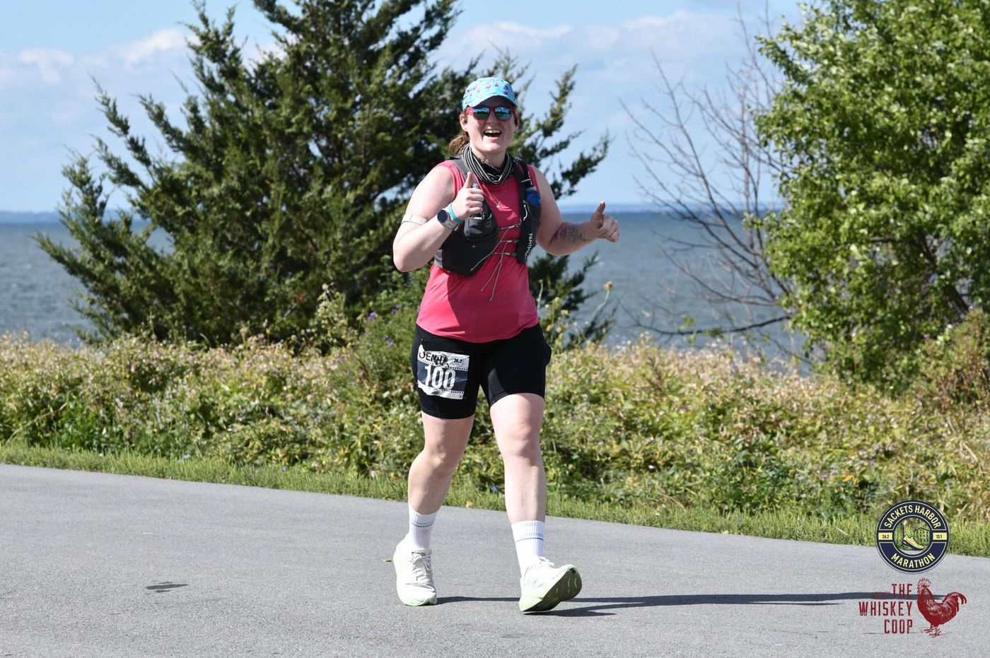 A runner giving a double thumbs-up on the lakeside course
